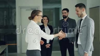 面试成功后，穿西装的“快乐男”在公司找到了工作，他握手微笑表示兴奋
